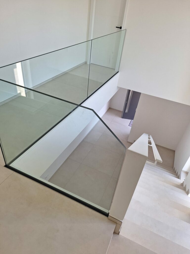 Modernes, rahmenloses Ganzglasgeländer im Innenbereich, maßgefertigt von metallic DESIGN Sàrl – hochwertiger Metallbau aus Luxemburg für exklusive Treppen- und Galerie-lösungen